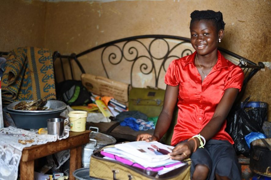 Jeune fille parrainée heureuse de montrer les lettres de ses parrains.