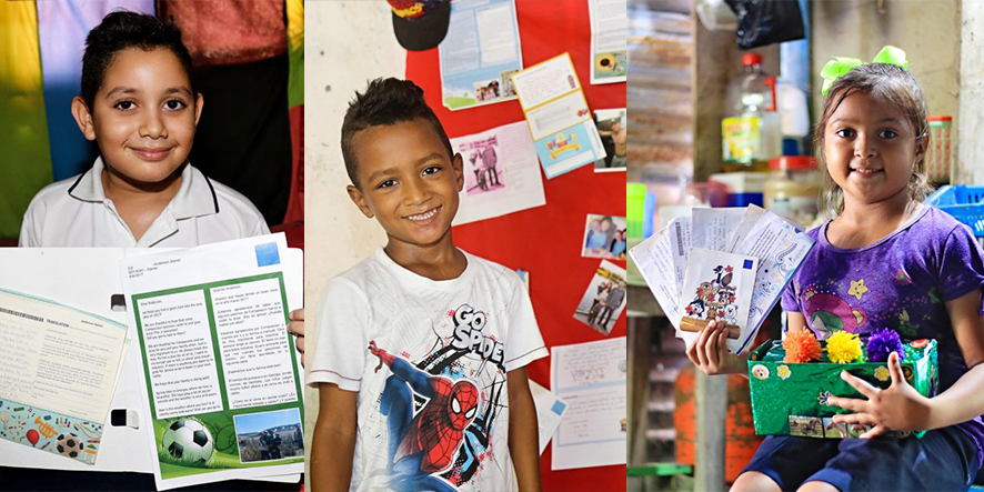 Enfants souriants tenant des lettres et des cartes dans le cadre d’un programme de parrainage
