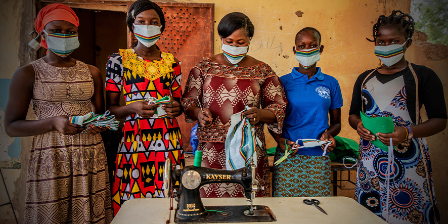 Cinq adolescentes avec des maques et leur machine à coudre.