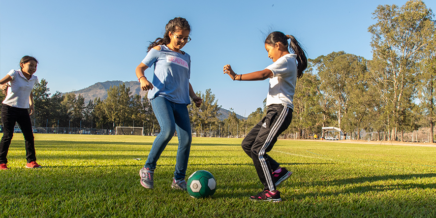 Trois filles jouant au ballon.