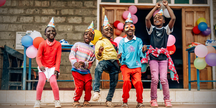 Cinq enfants heureux avec des chapeaux de fête sur la tête.