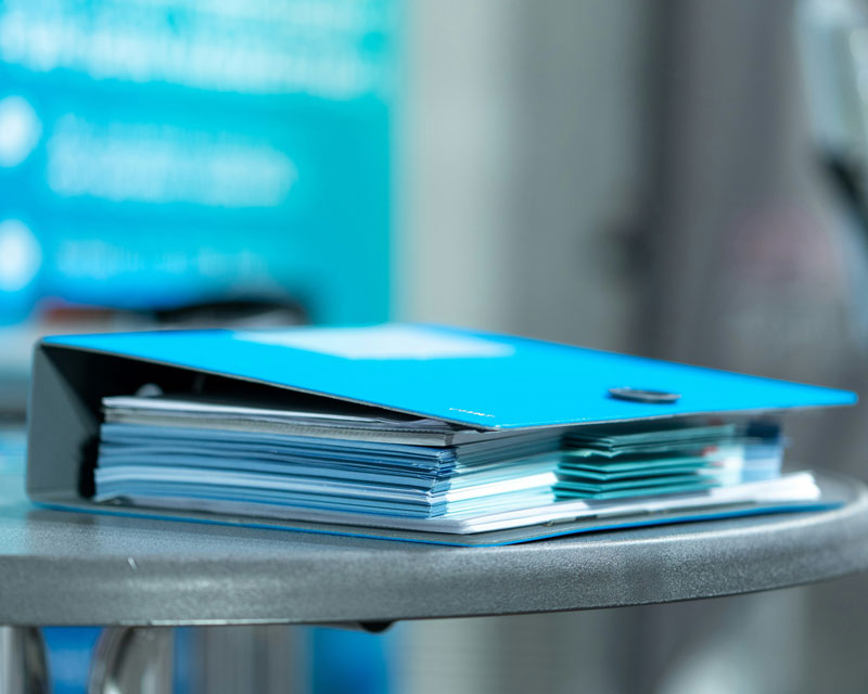 Image montrant un classeur de couleur bleu posé sur une table Image montrant un classeur de couleur bleu posé sur une table