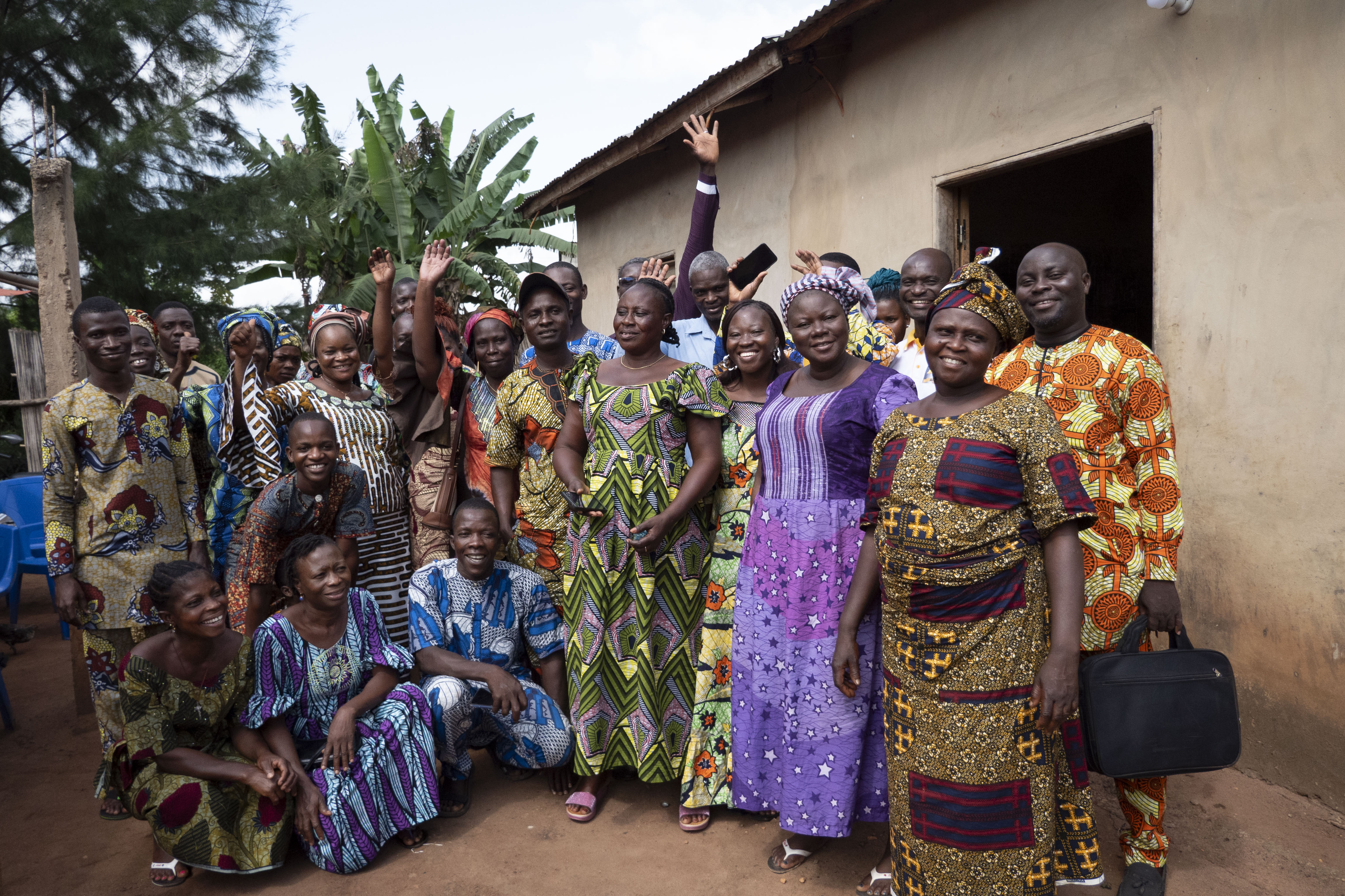 Groupe de personnes souriantes vêtu de tenues traditionnelles.