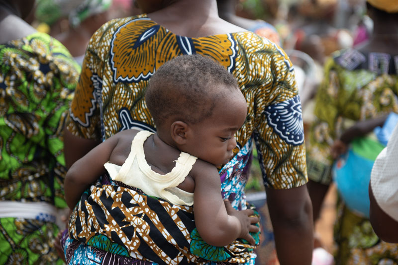 Image d'une femme portant son enfant au dos. Image d'une femme portant son enfant au dos.