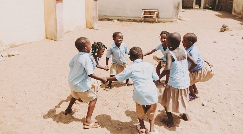Sept enfants faisant la ronde et s'amusant.