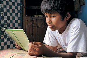 Enfant qui lit une lettre.